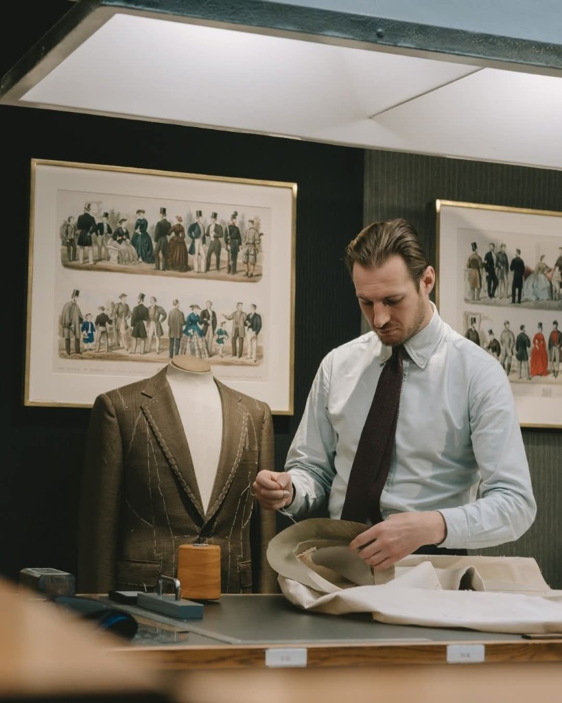 Master tailor hand-sewing a bespoke suit jacket in a professional workshop in Bahrain and Saudi Arabia